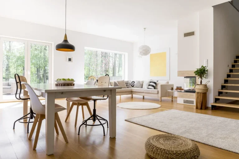 Modern dining room with wooden table and chairs, bright interior.